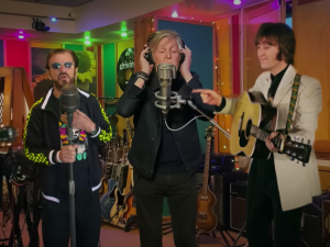 Concert des Beatles grâce à l'intelligence artificielle. On y voit John Lennon et George Harrisson chanter aux côtes de Paul McCartney et Ringo Star. Cela montre un retour possible grâce à l'intelligence artificielle.