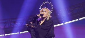 Madonna lors de son Célébration Tour, habillée comme une Madonne et coiffée avec une auréole sur la tête. Le stade semble rempli. Cela marque le retour en force de la chanteuse.